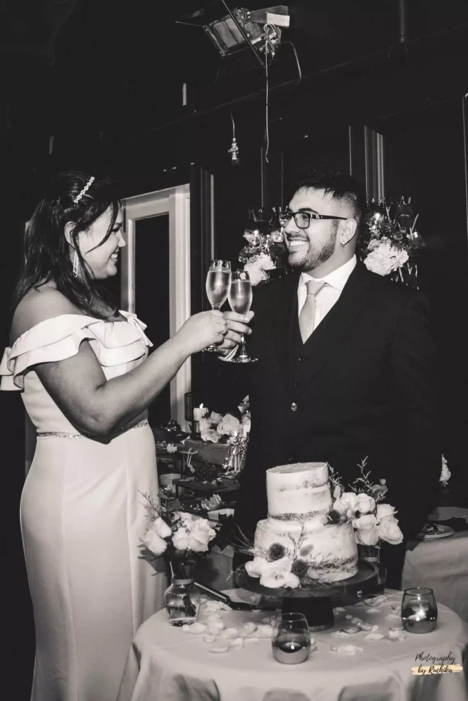 Intimate black and white photo of a newlywed couple sharing a moment during their wedding reception with wine - Wedding Photographer, Wellington.