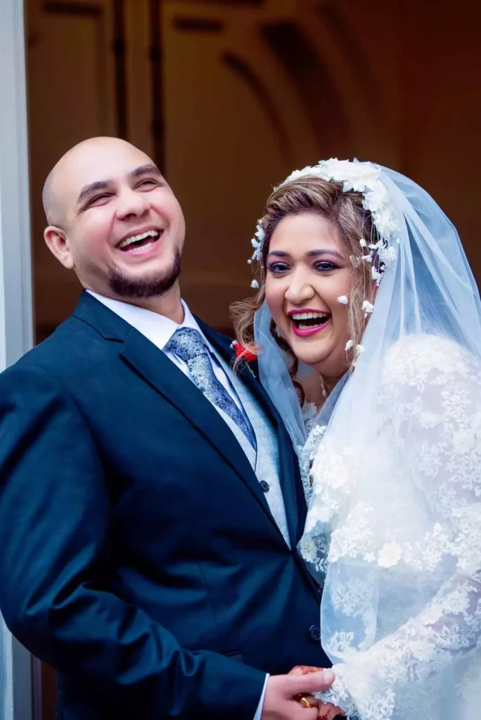 Bride and groom sharing a joyful moment, both smiling and laughing together