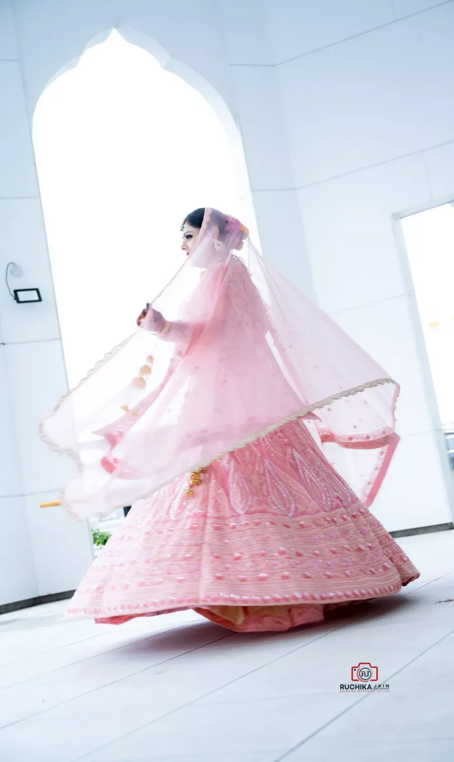 Bride spinning in a pink lehenga during a Sikh wedding