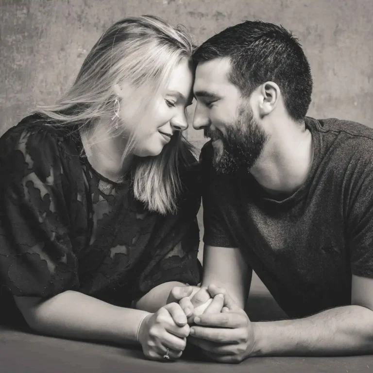 Couple sharing an intimate moment while holding hands and leaning their foreheads together