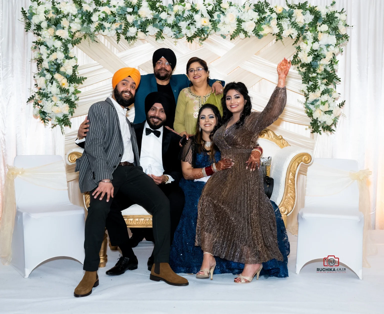 A happy family group posing together at a beautifully decorated wedding ceremony in Wellington.