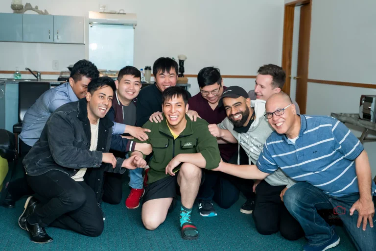 Group of men smiling and posing indoors during a casual gathering