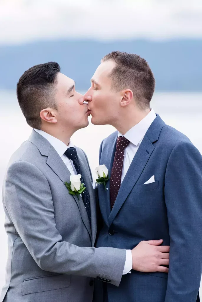 A touching moment of a newlywed couple sharing a kiss, symbolizing love and commitment, set against the serene backdrop of Wellington.