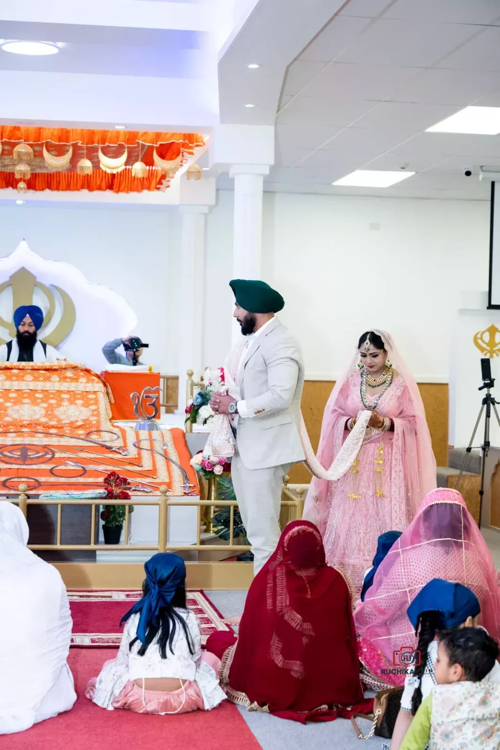 Sikh bride and groom walking around the Guru Granth Sahib during wedding ceremony