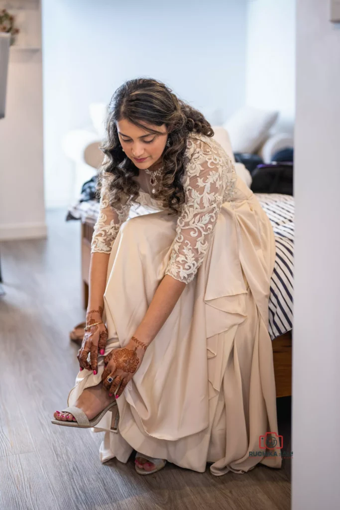 Bride in an elegant gown adjusts her high heels while preparing for the wedding ceremony