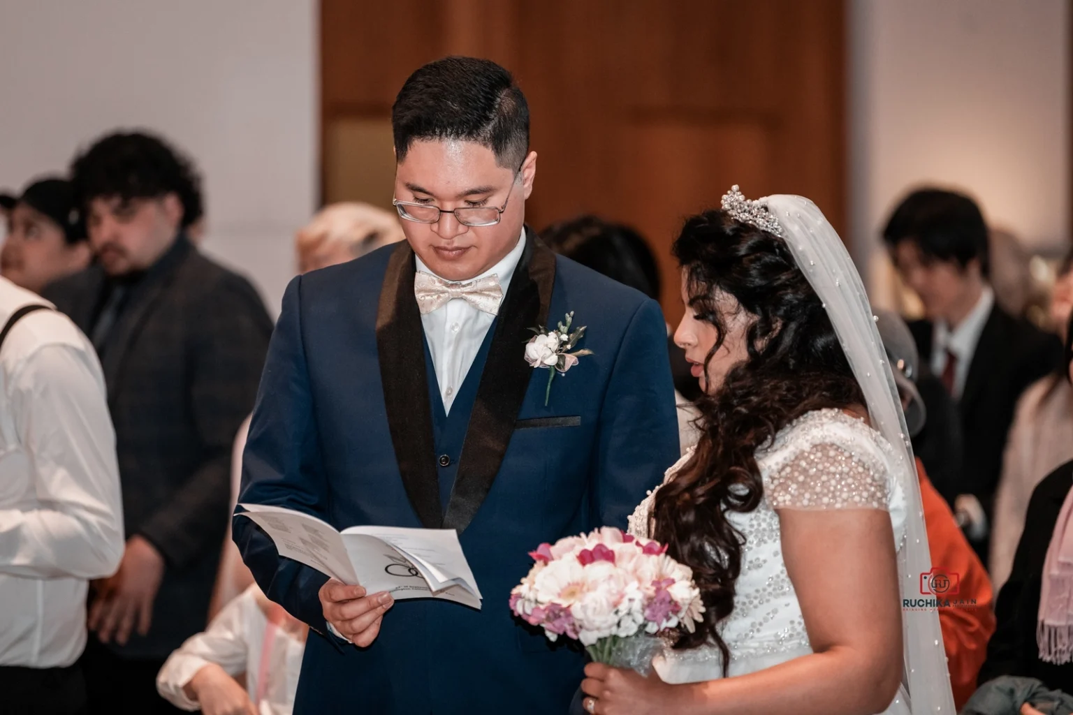 Bride and groom reading from booklet during wedding ceremony