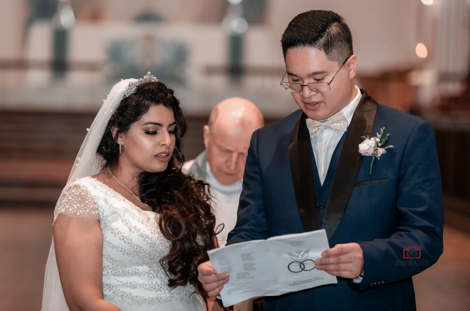 Bride and groom recite vows during a wedding ceremony with officiant in the background