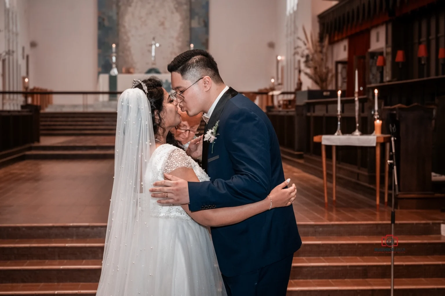 The bride and groom share their first kiss as newlyweds in front of the altar at the Wellington Cathedral of St. Paul