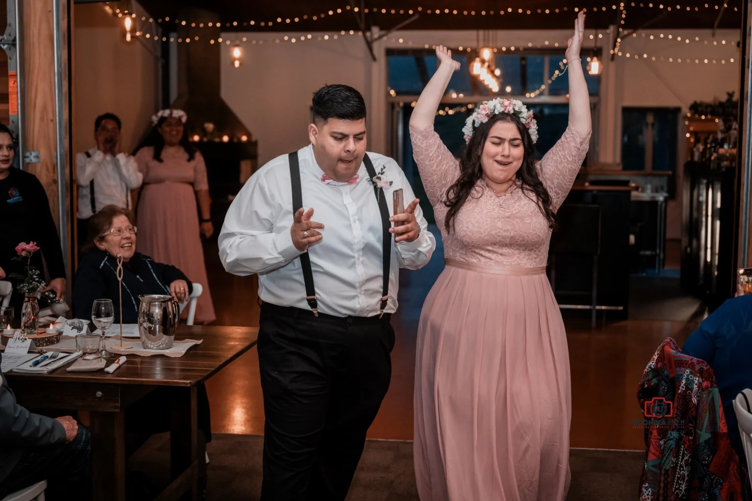 Wedding guests in festive attire dance and celebrate at the reception