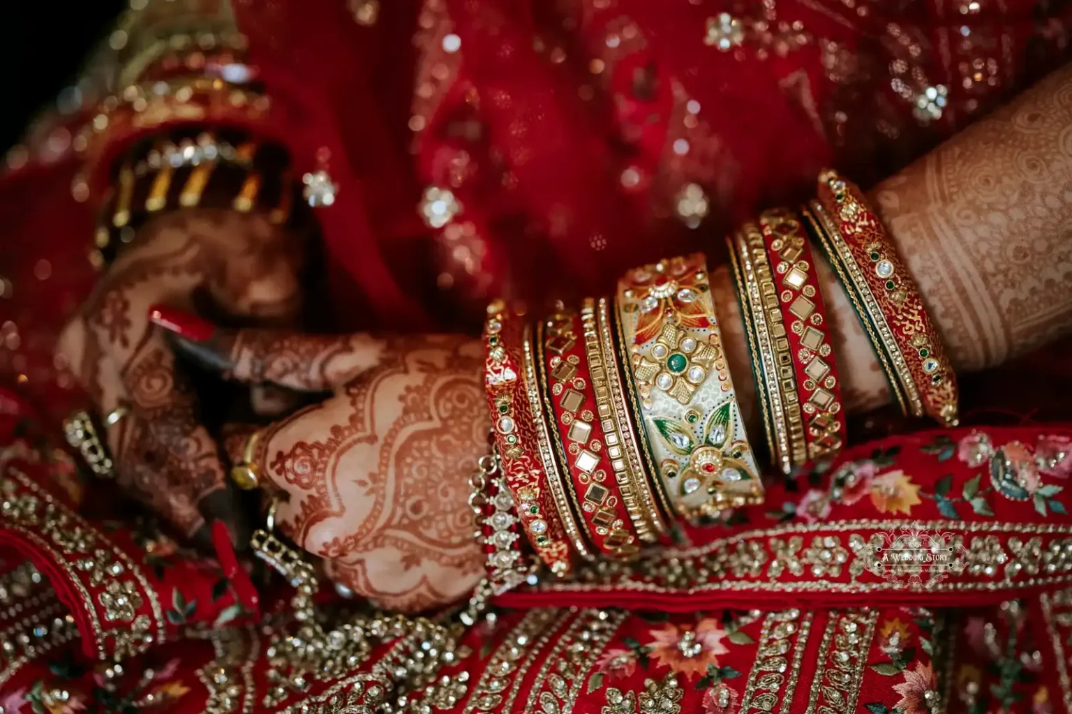 Close-up of the bride's henna-adorned hands and vibrant bangles, showcasing intricate details in a traditional Indian wedding setting.