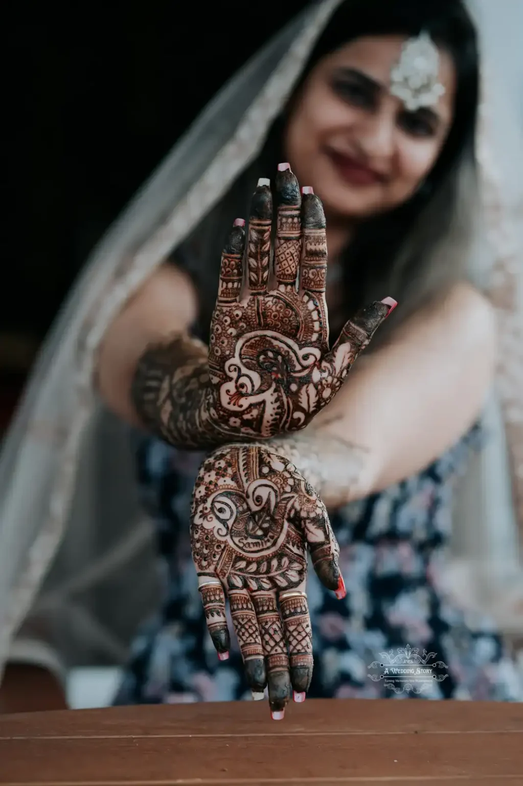 Close-up of a bride’s beautifully designed mehndi on her palms with her face softly blurred in the background, showcasing the intricate details of traditional henna art during a Mehndi ceremony in Wellington