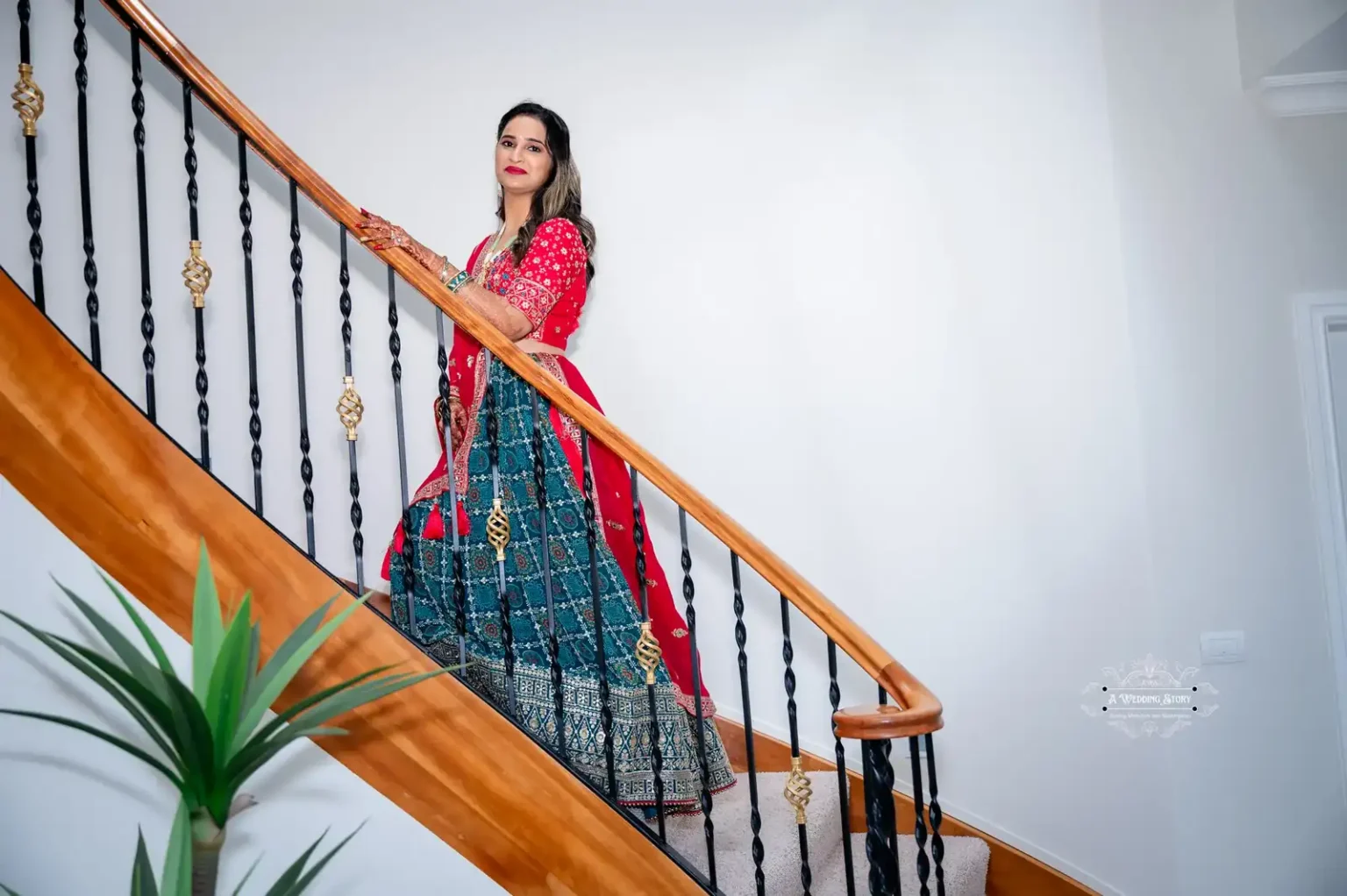 Bride in traditional attire standing gracefully on a staircase, captured by Wedding Photography in Wellington