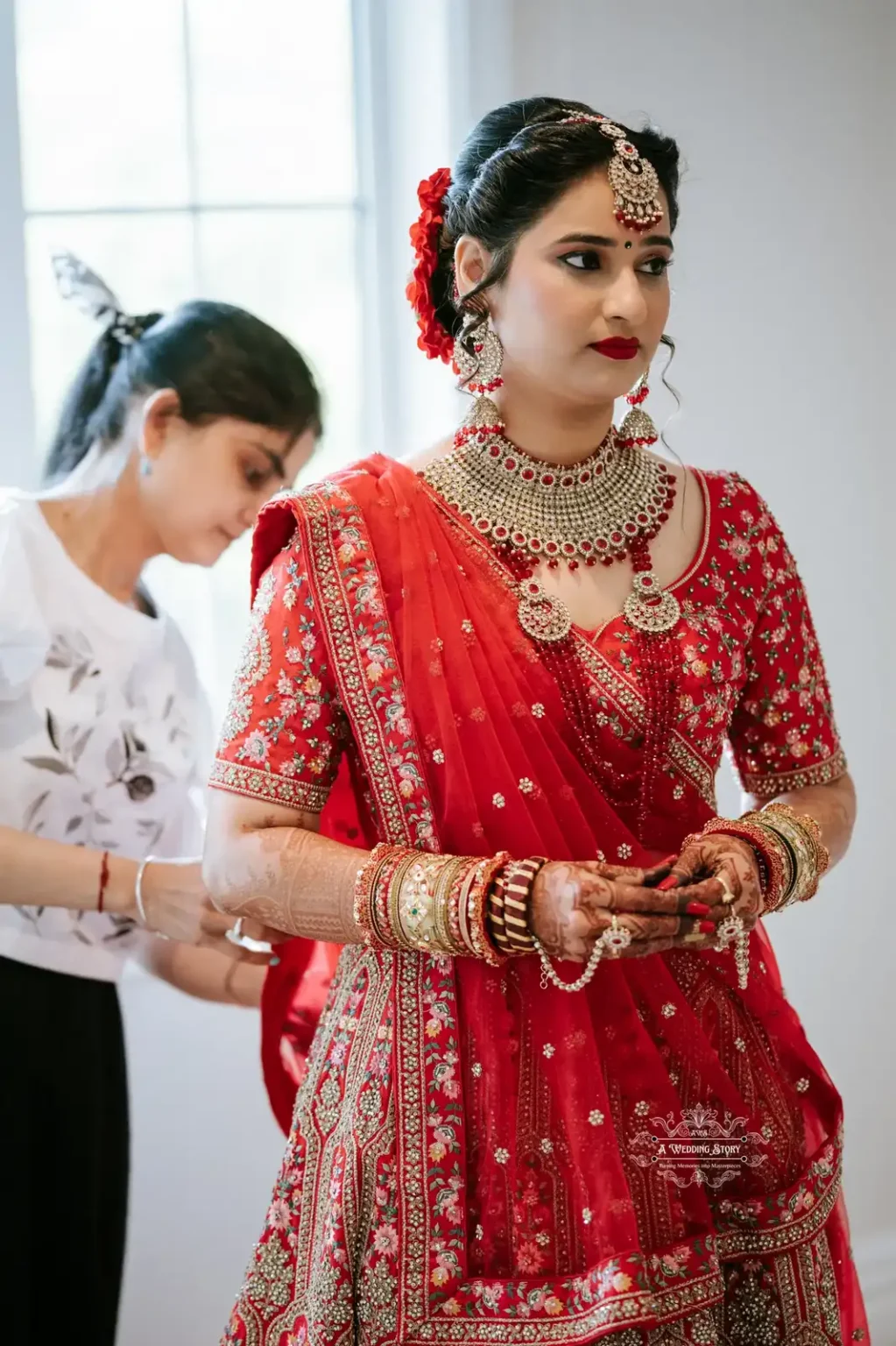 Bride in red bridal attire during wedding preparations, adorned with jewelry, captured by Wedding Photography in Wellington