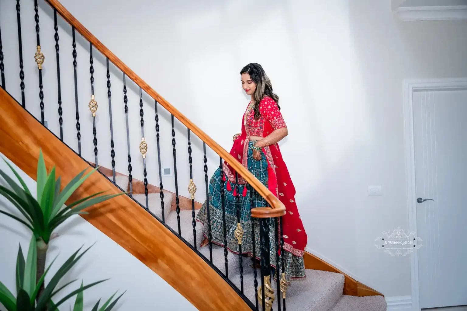 Bride in traditional attire descending a staircase, captured by Wedding Photography in Wellington