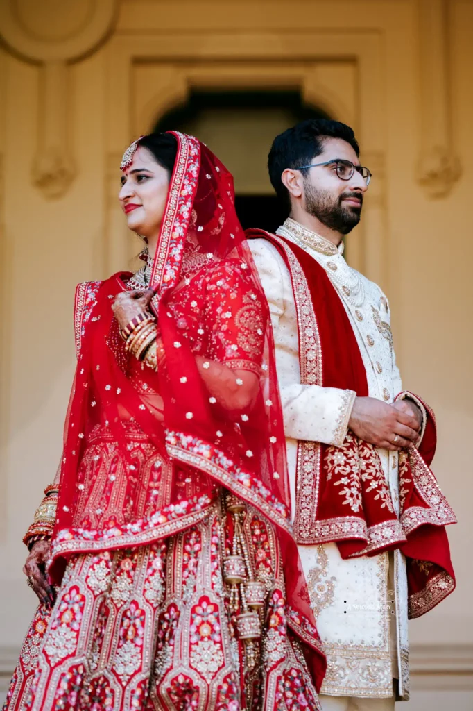 Gujarati bride and Kiwi groom in traditional Sherwani and Gujarati wedding attire, showcasing cultural fusion and love during their wedding photoshoot.