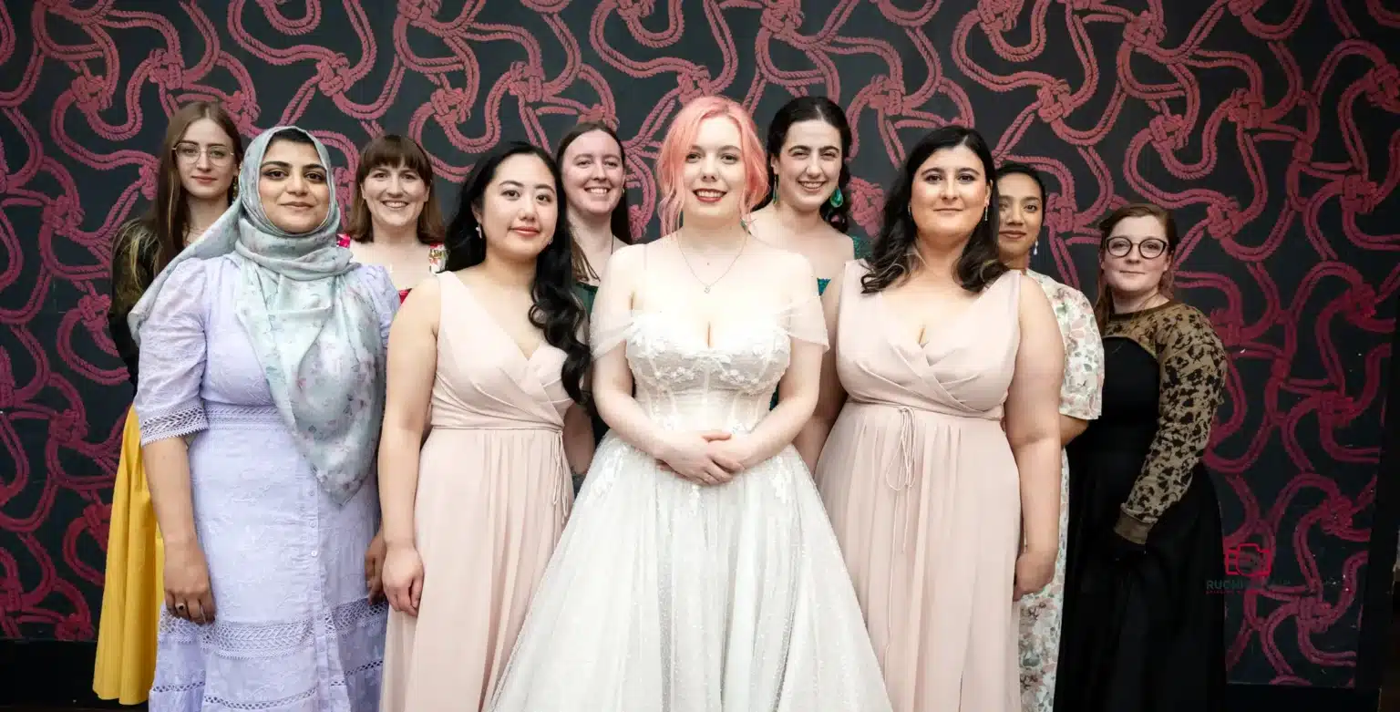 Bride standing with bridesmaids and friends in a group portrait at a Wellington wedding