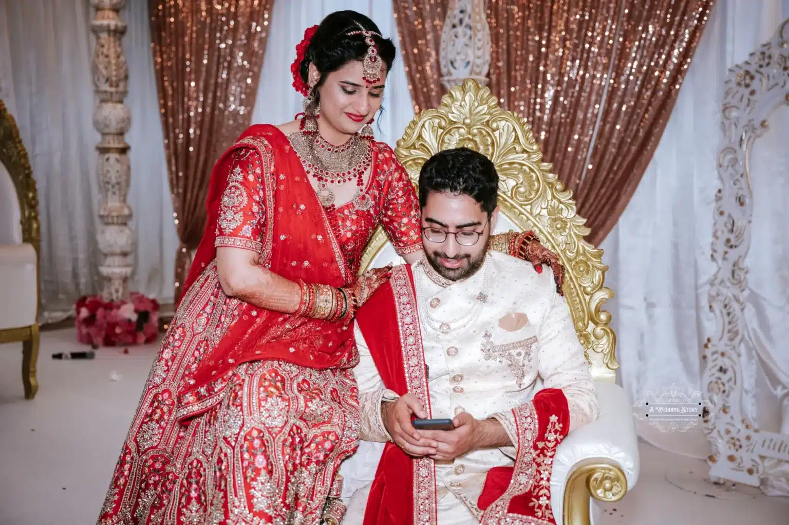 Indian bride and groom sharing a relaxed moment, with the groom looking at his phone, captured in Wellington by Wedding Photography.