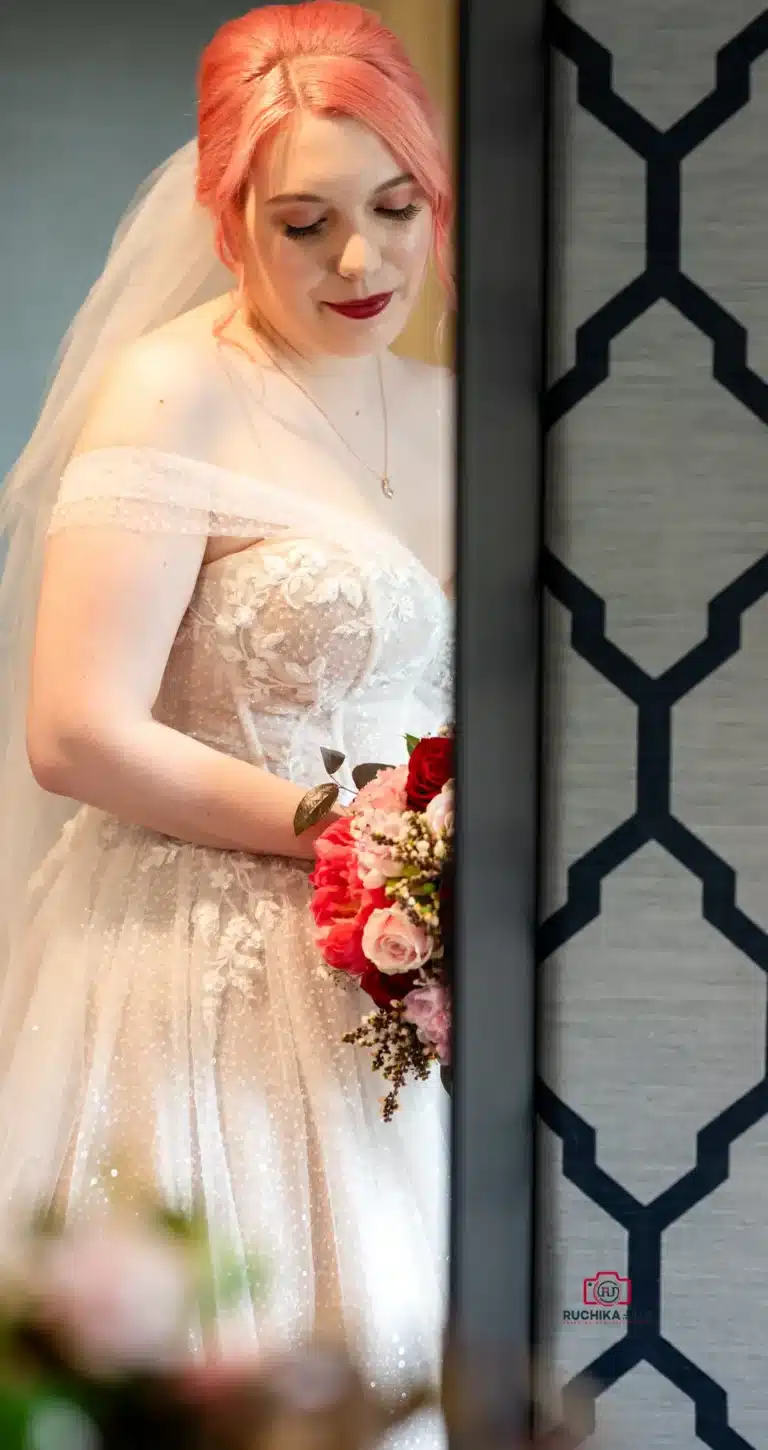 Bride holding a vibrant bouquet with her eyes closed, reflecting a serene moment before the ceremony