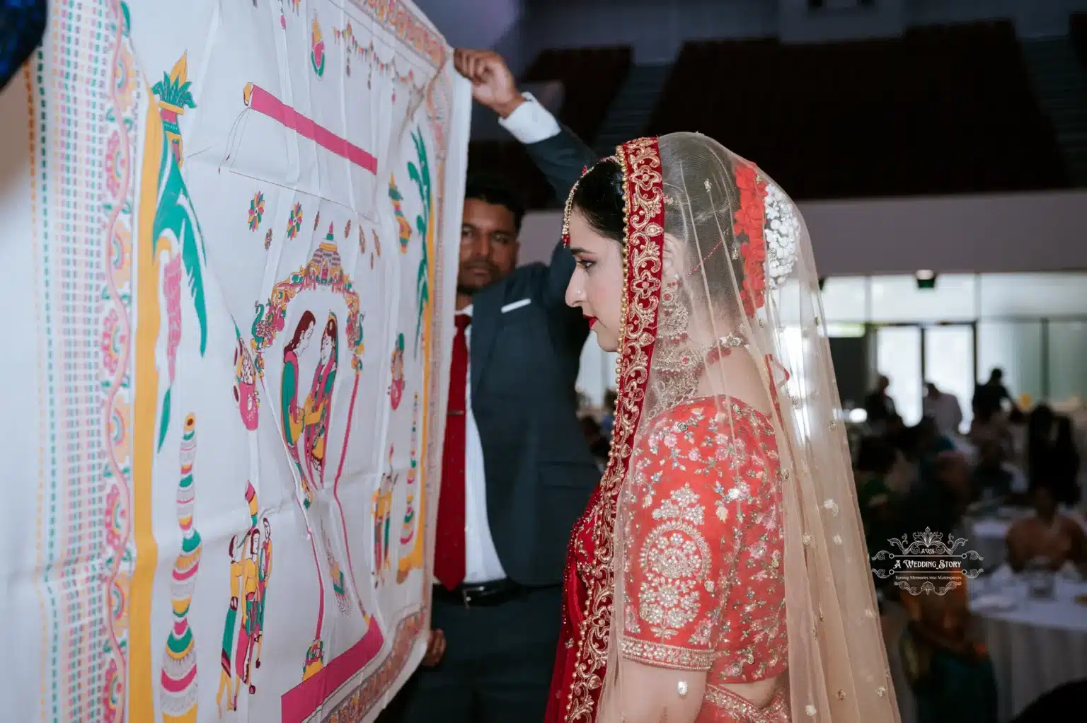 Bride in traditional red attire, standing in front of a ceremonial curtain during the wedding ritual.