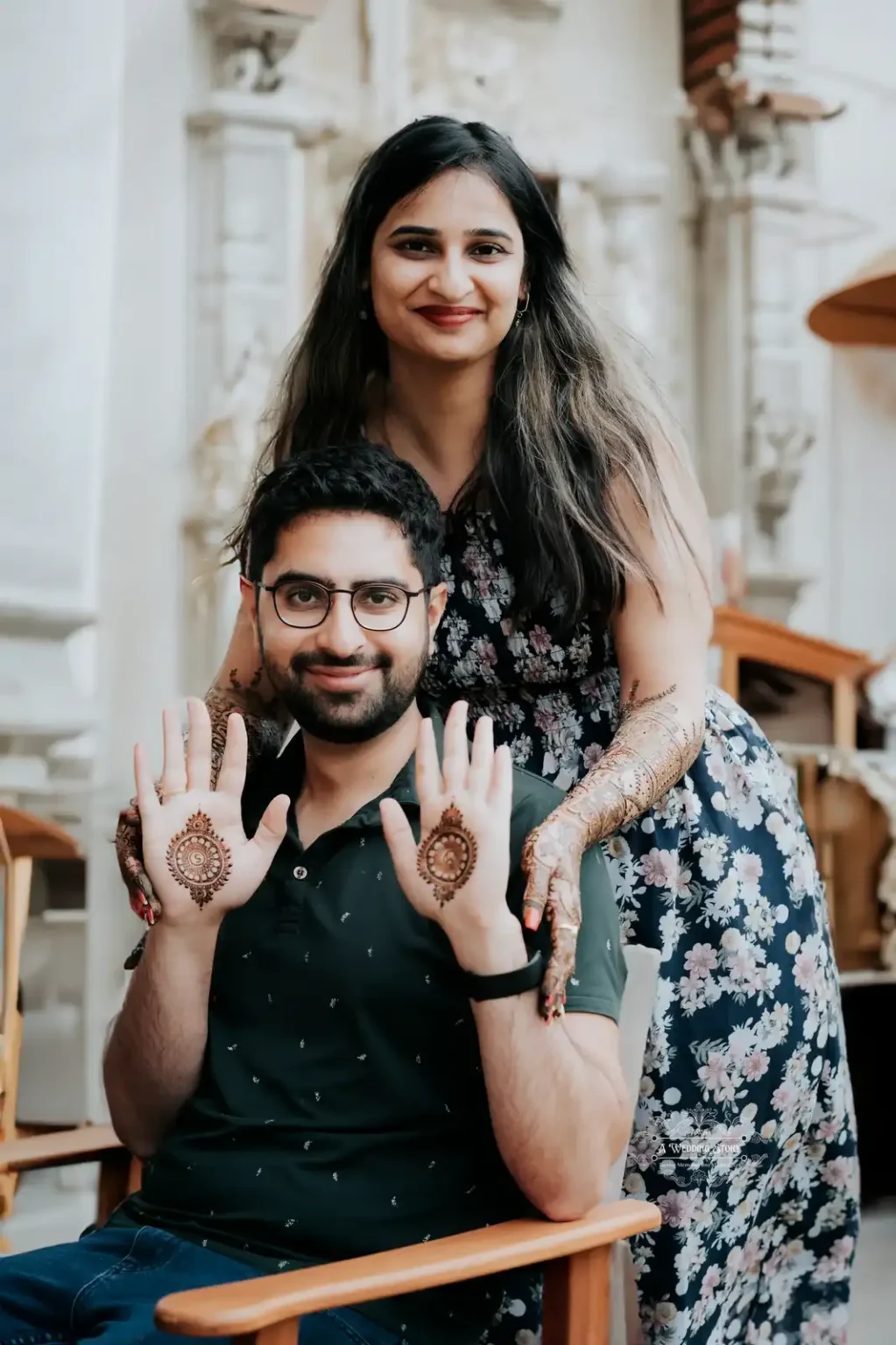 Smiling bride and groom showcasing intricate mehndi designs during a pre-wedding celebration, captured in a candid moment in Wellington by A Wedding Story