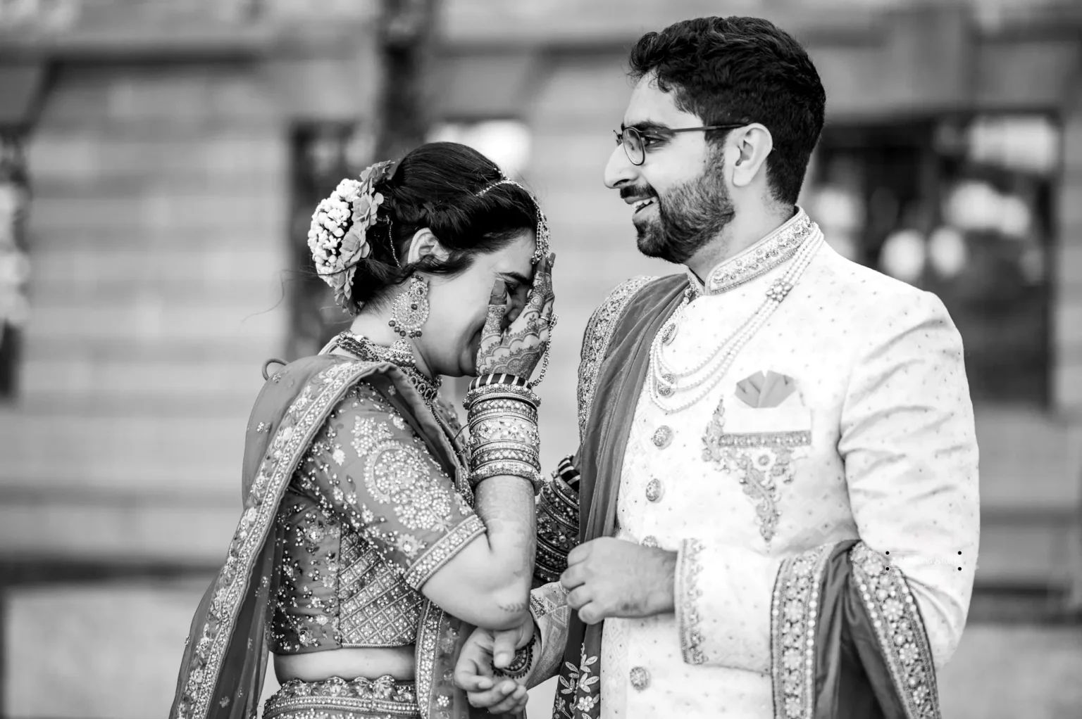 Black and white photo of bride covering her face in an emotional moment with the groom, during their wedding in Wellington, New Zealand.