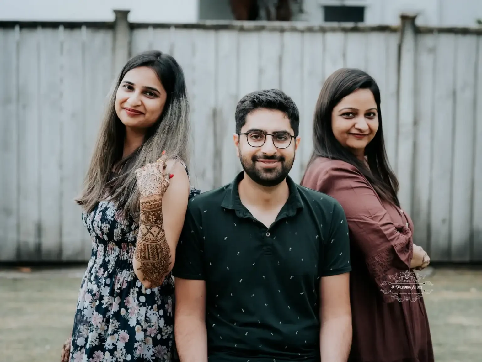 Smiling bride, groom, and family member posing together during a pre-wedding mehndi celebration, captured by A Wedding Story in Wellington