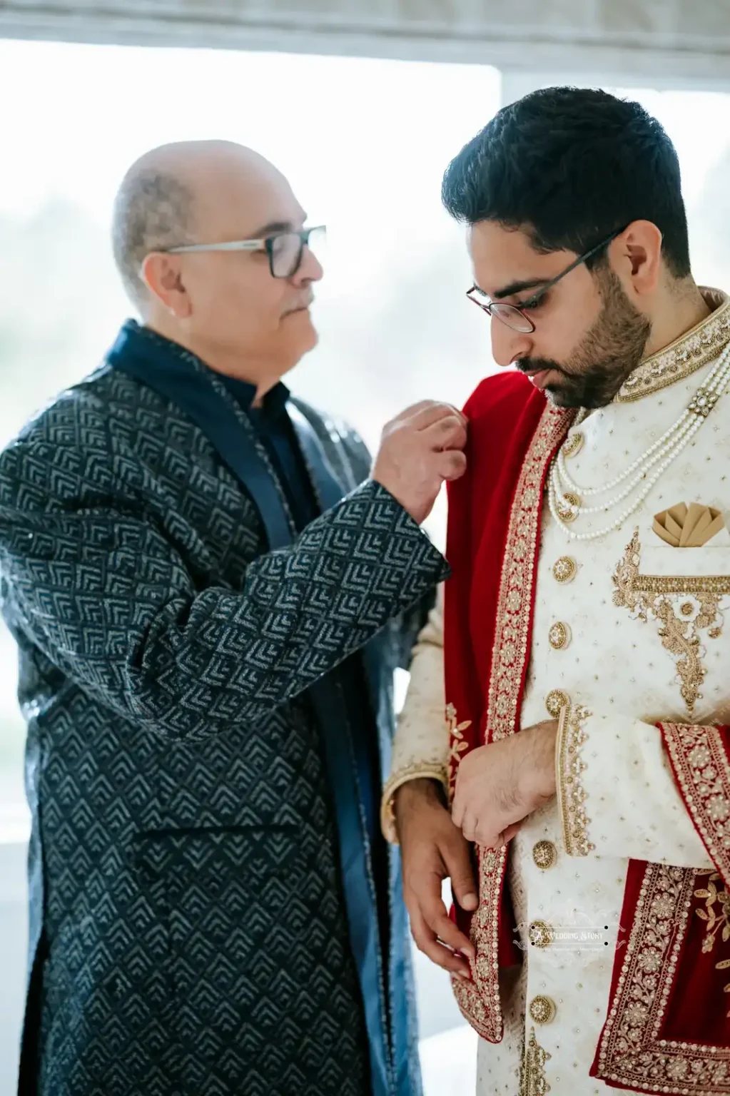 Indian groom being assisted by his father with his traditional wedding attire, captured in Wellington by Wedding Photography.