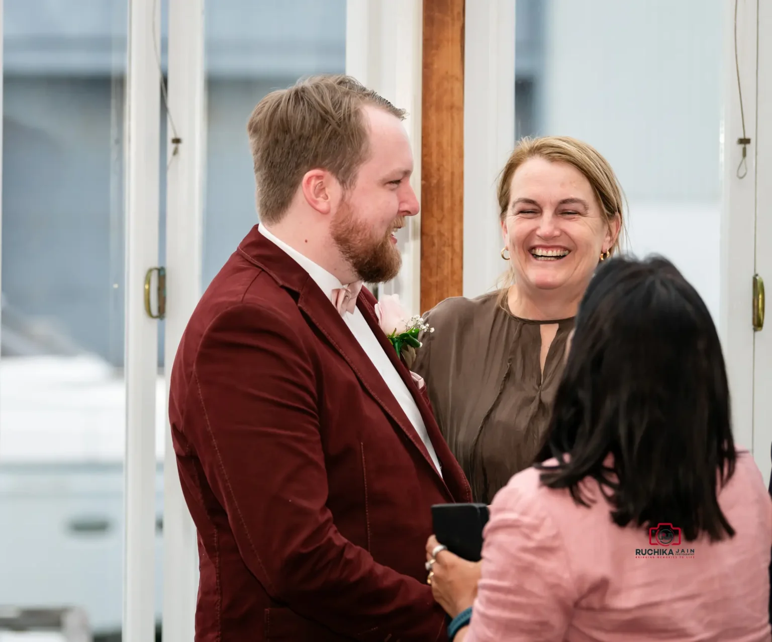 Groom smiling and sharing a joyful moment with friends at a Wellington wedding