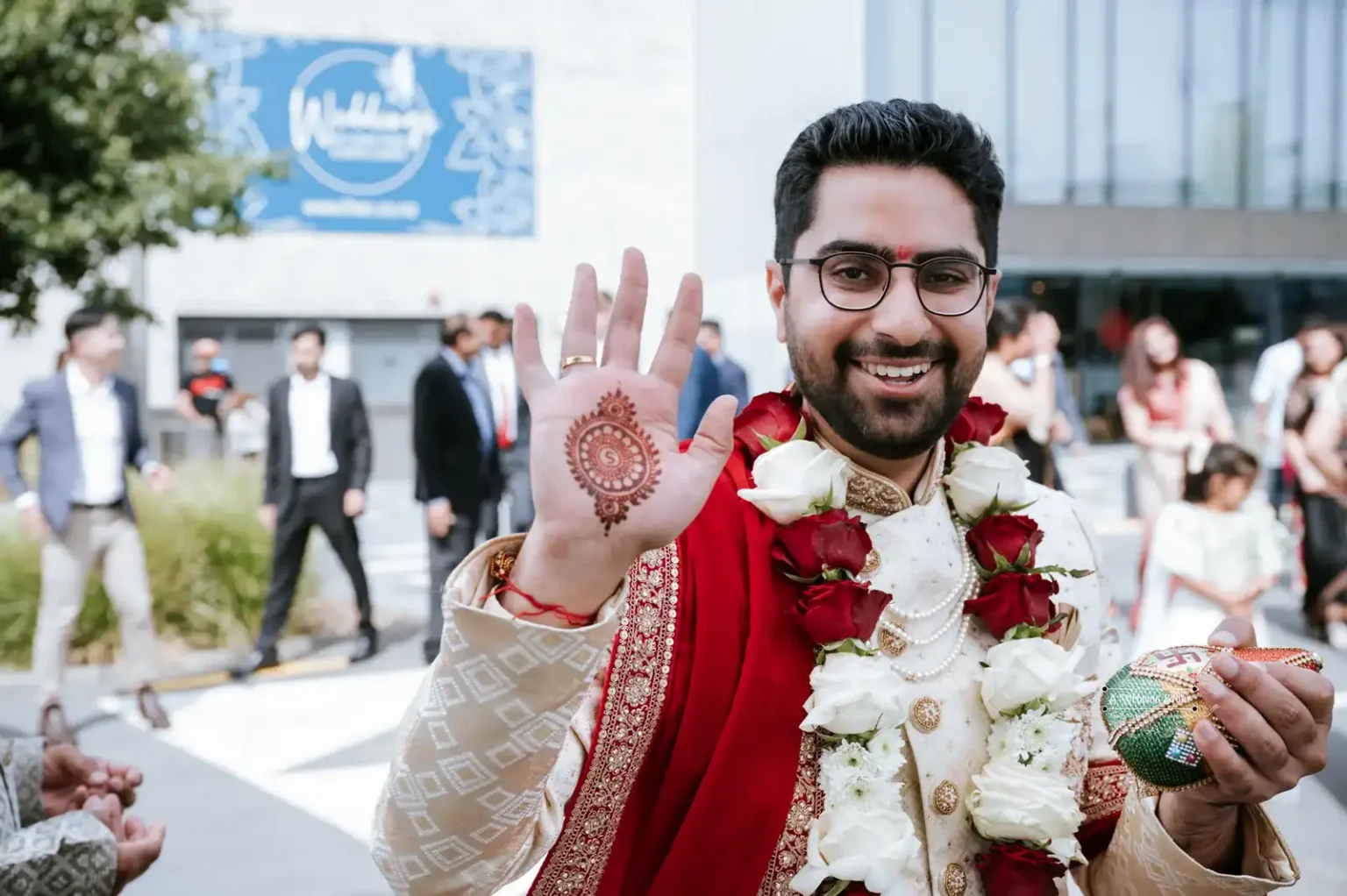 Groom smiling and showing mehndi design on hand during wedding ceremony, captured by Wedding Photography in Wellington