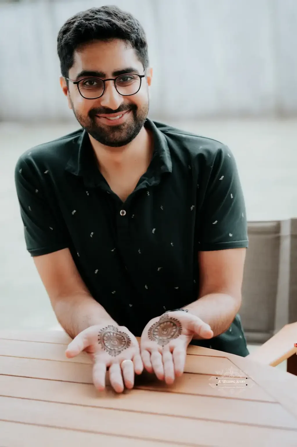 Smiling groom showcasing minimal mehndi designs on his palms during a pre-wedding celebration, captured by A Wedding Story in Wellington