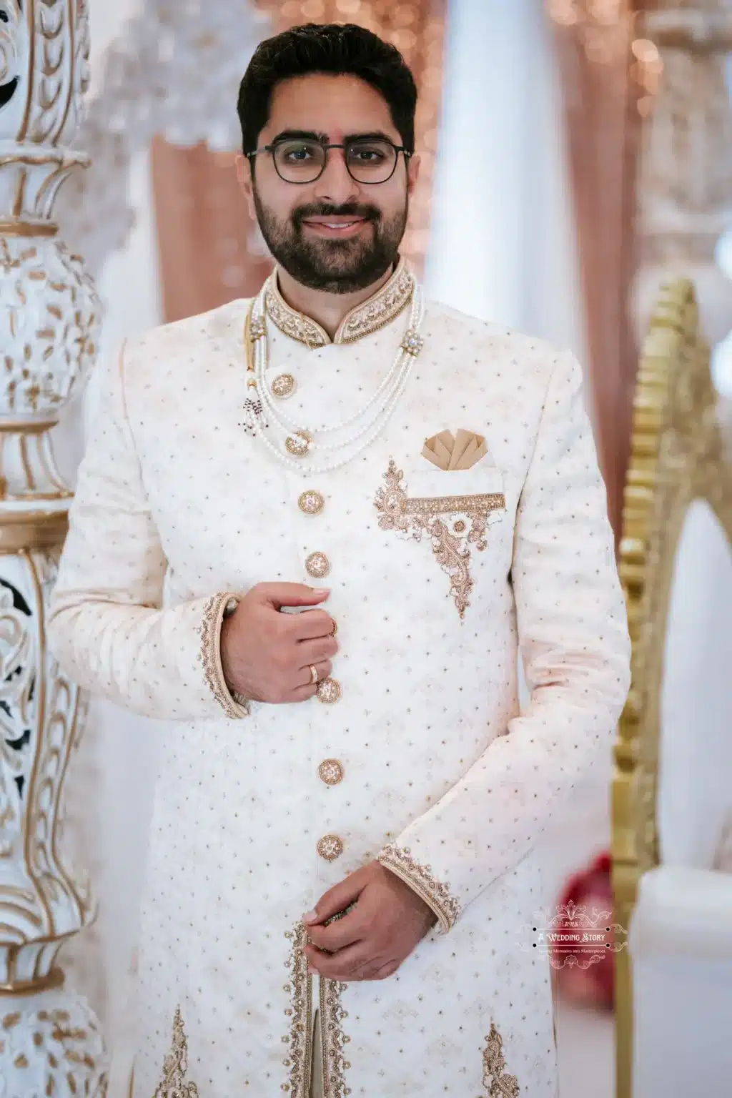 Portrait of the groom in an elegant white sherwani with intricate detailing, smiling confidently.