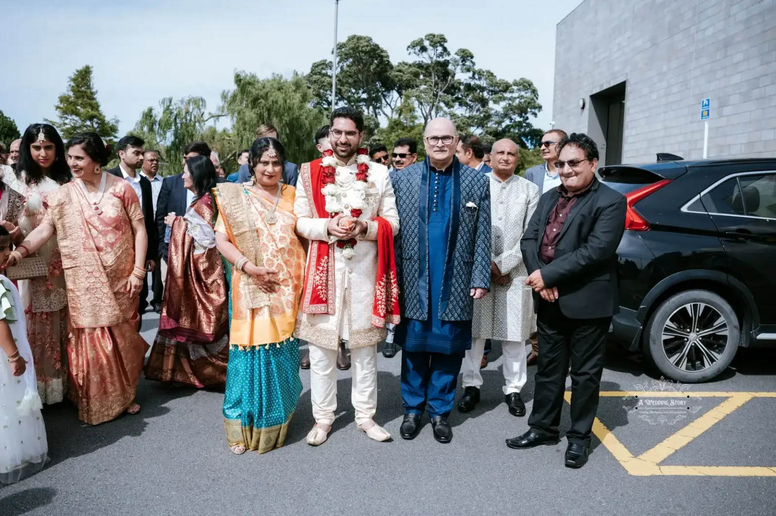 Groom in traditional Indian wedding attire standing with family and guests during a wedding ceremony in Wellington, captured by A Wedding Story