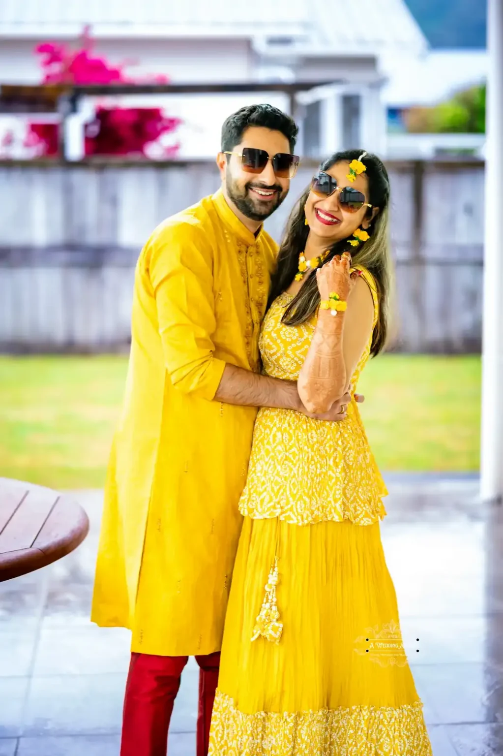 Smiling couple in traditional yellow attire at their Haldi ceremony in Wellington.