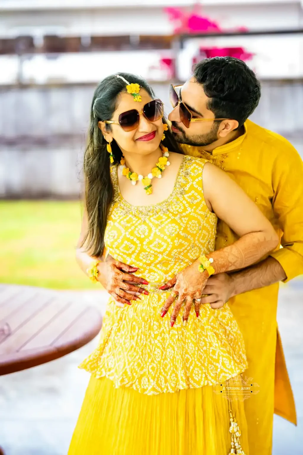 Bride and groom sharing a lighthearted moment outdoors during the Haldi ceremony in Wellington, wearing matching yellow outfits and sunglasses.