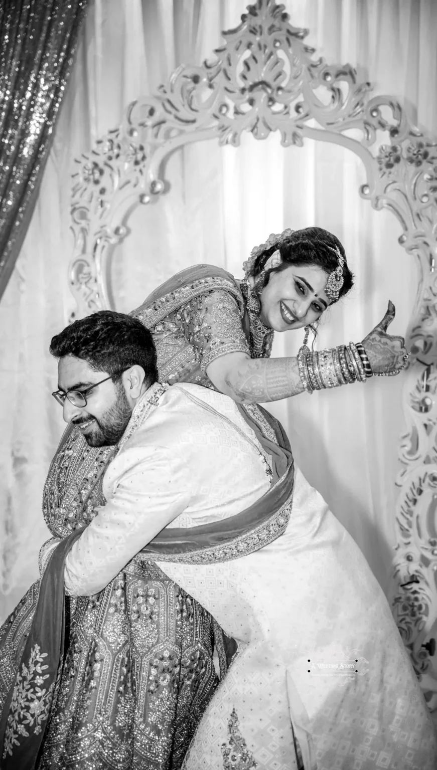 Black and white image of Indian bride and groom sharing a playful moment during their wedding, with the bride giving a thumbs-up, captured in Wellington by Wedding Photography.