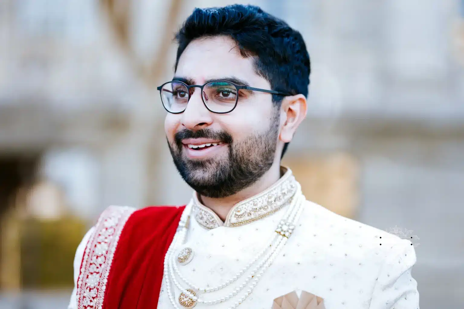 Close-up of a smiling groom in traditional attire during his wedding in Wellington, New Zealand.