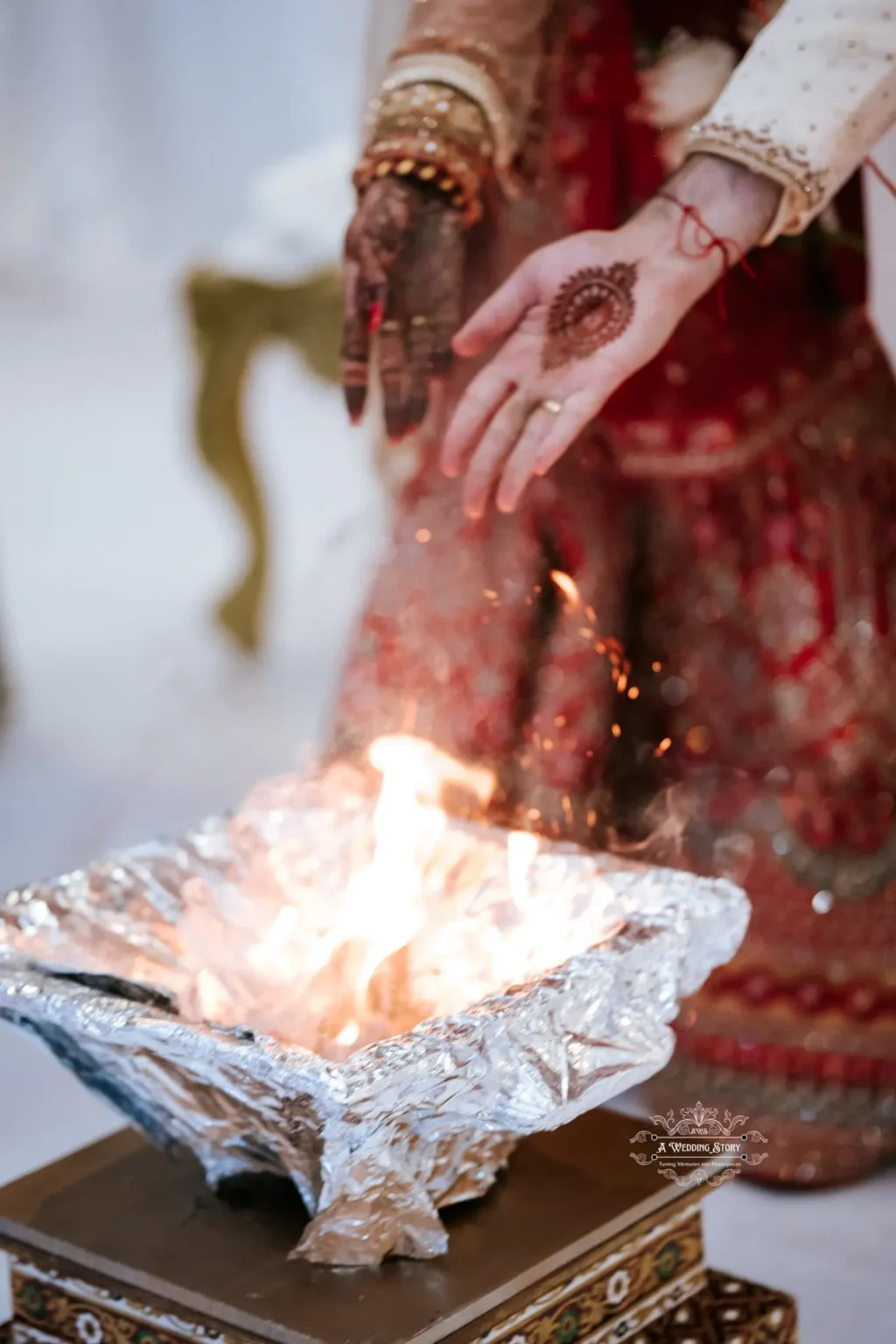 Close-up of the bride and groom's hands over the sacred fire during a traditional wedding ritual.