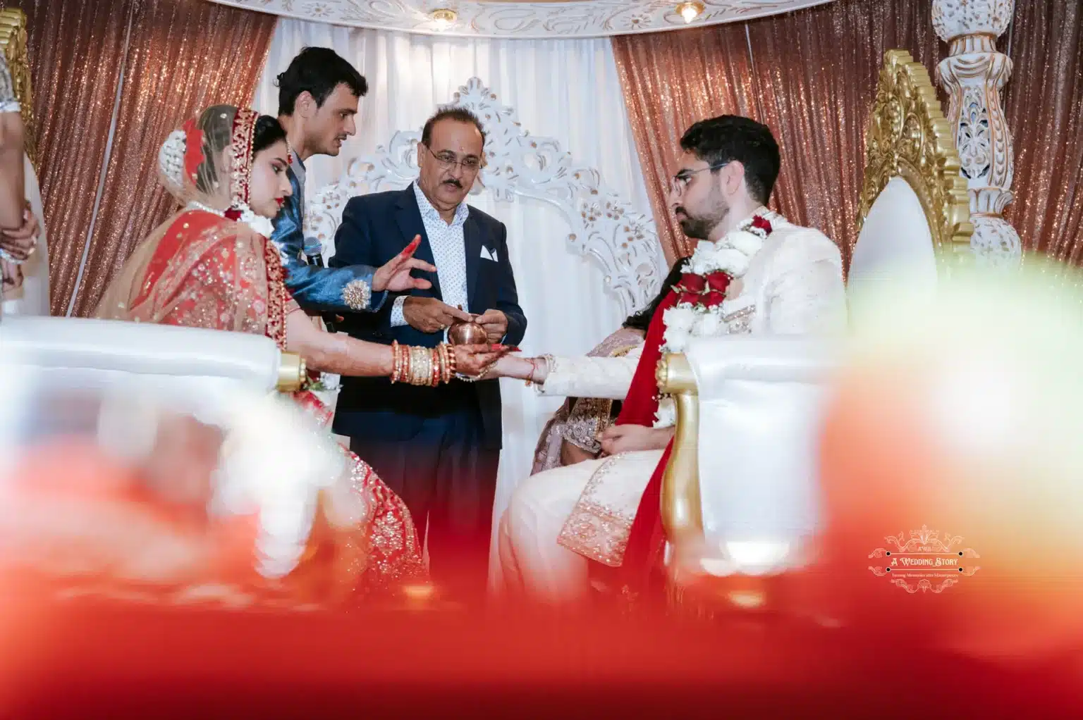 Bride and groom participate in a traditional wedding ritual with family members, symbolizing cultural customs and blessings.