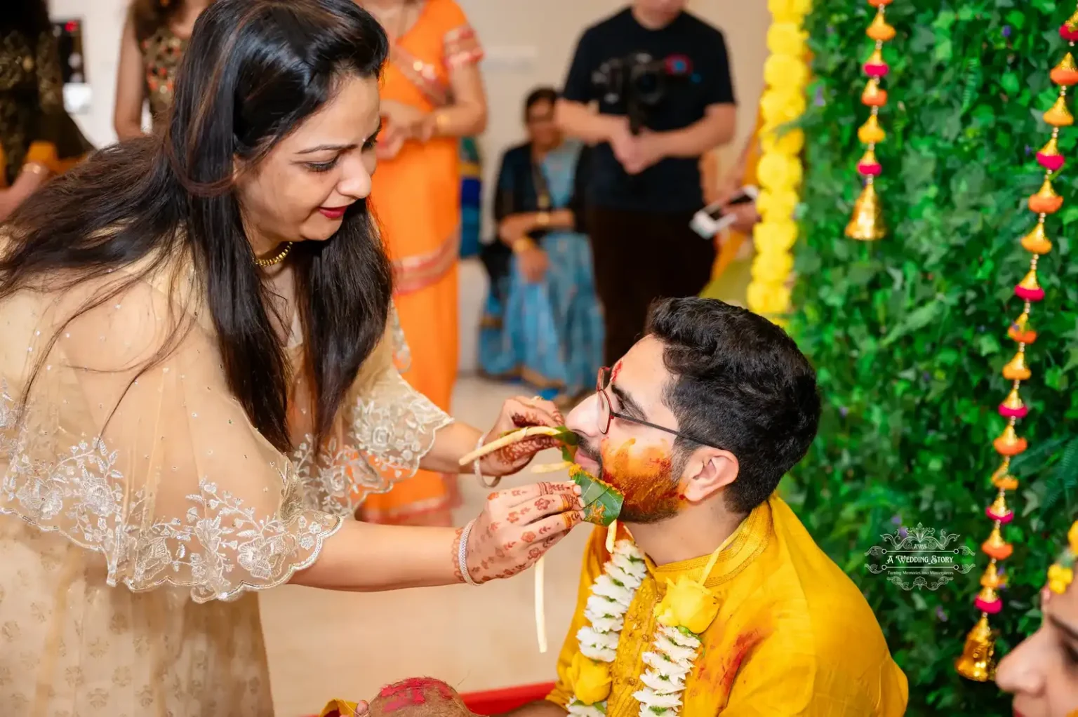 Bride’s sister feeding the groom with traditional Haldi ceremony rituals, creating a heartfelt moment in Wellington.