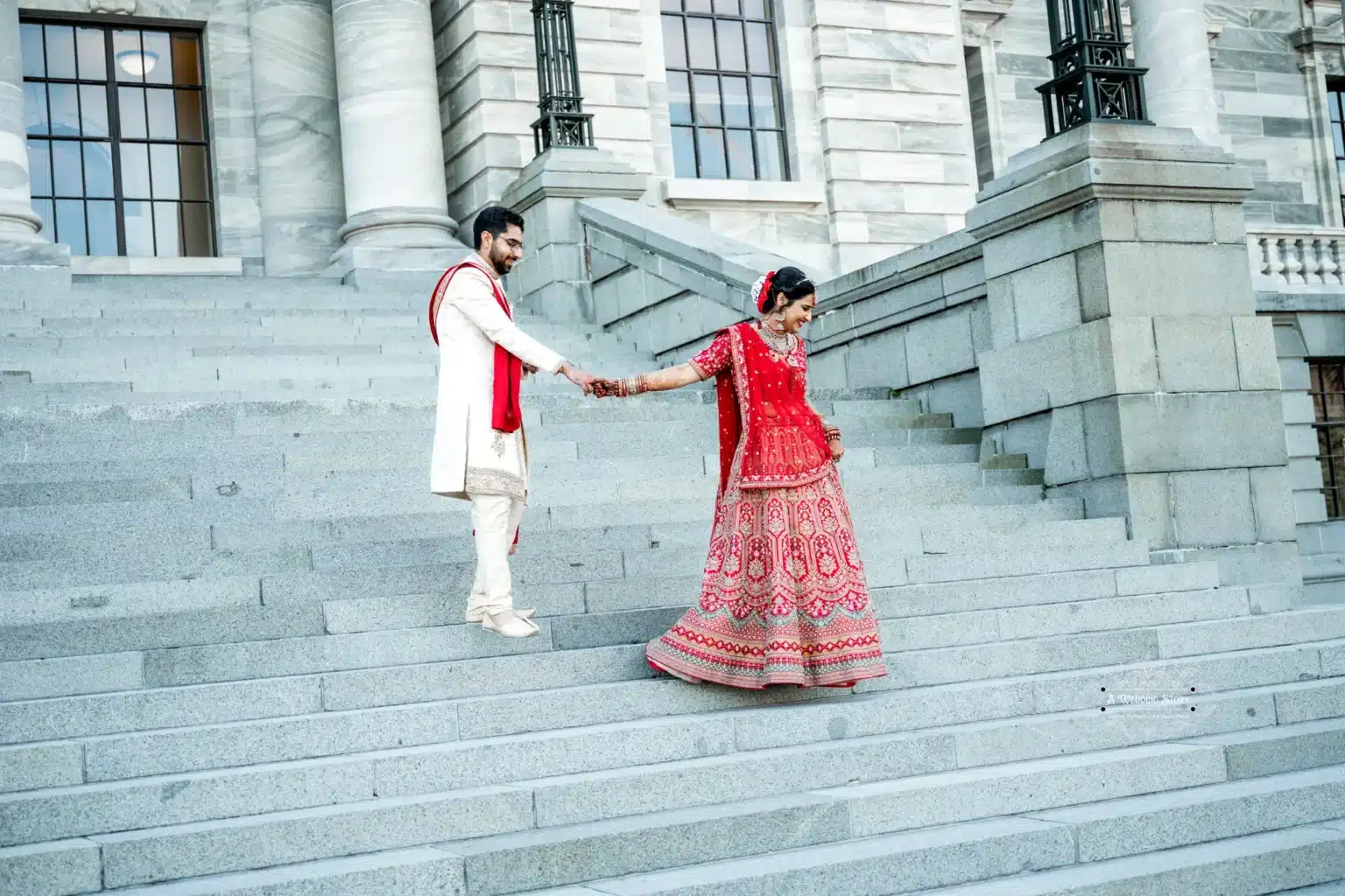 Groom leading bride down the steps of a historic building in Wellington, New Zealand.