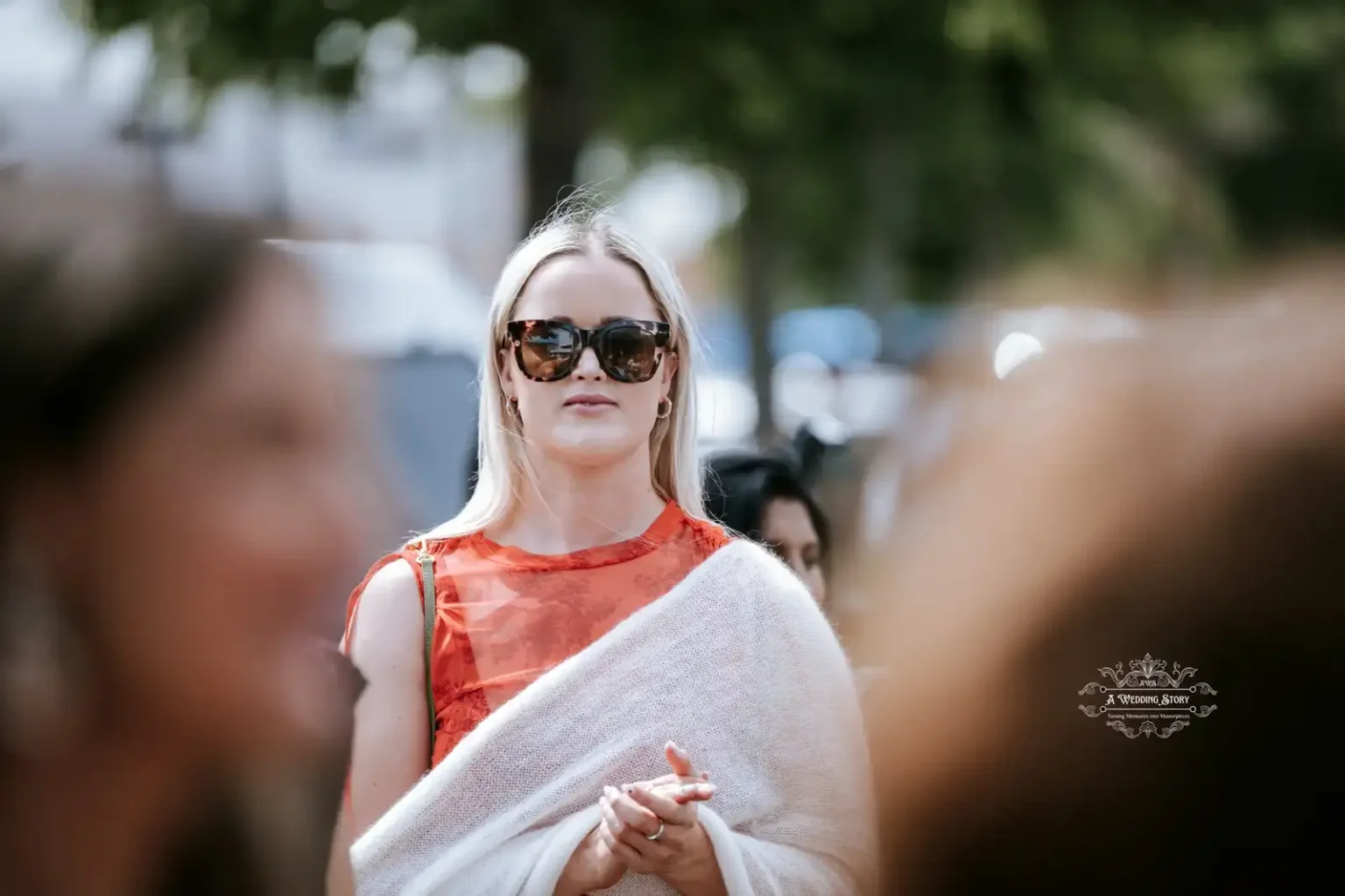 Female wedding guest in sunglasses and shawl observing the celebration, captured by Wedding Photography in Wellington