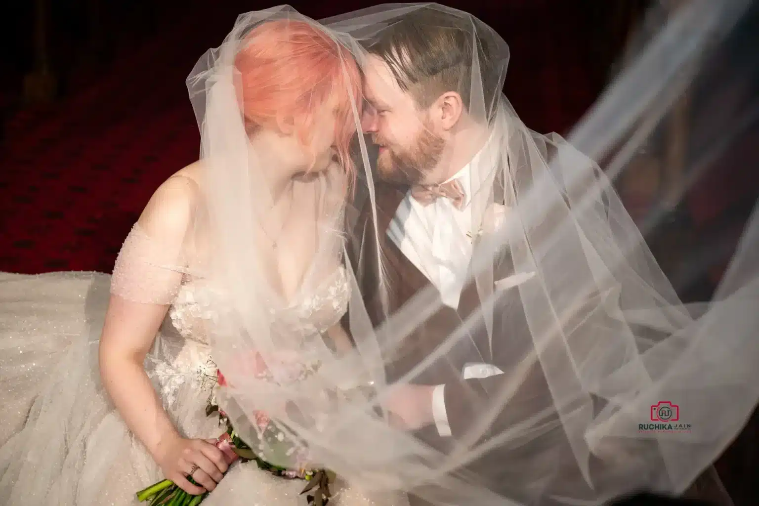 A beautiful wedding photography moment of a bride and groom under a veil, captured with elegance and emotion.