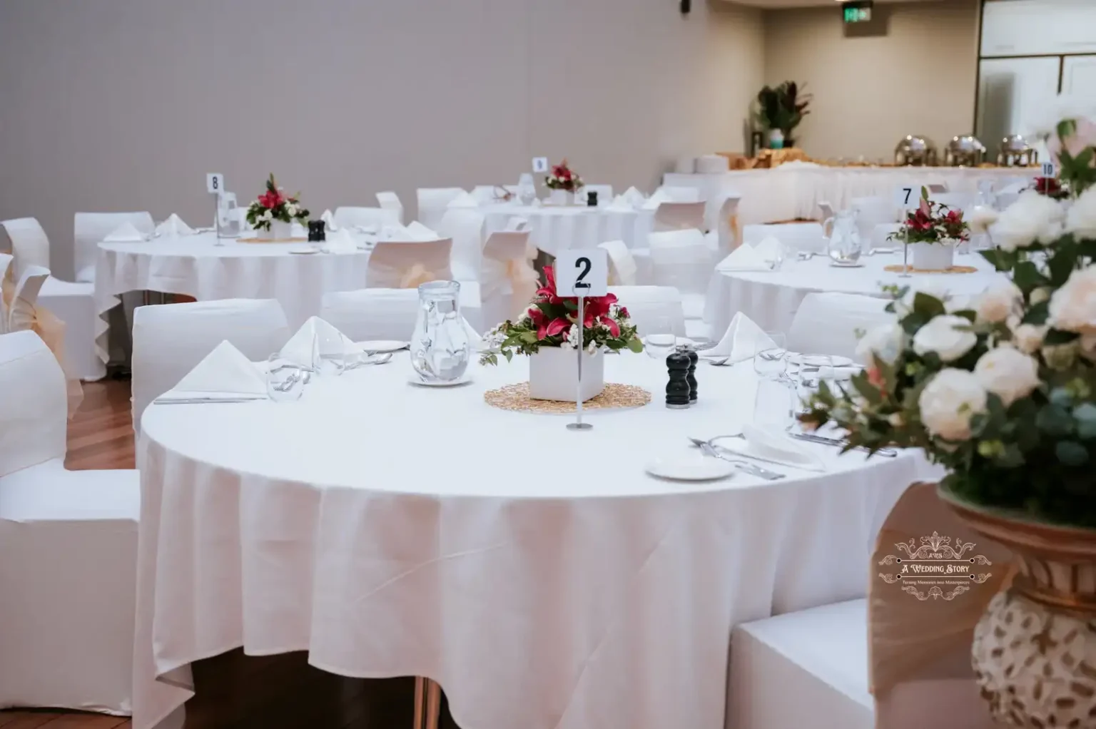 Beautifully decorated wedding table with white linens, floral centerpieces, and neatly arranged cutlery captured at a reception in Wellington by A Wedding Story