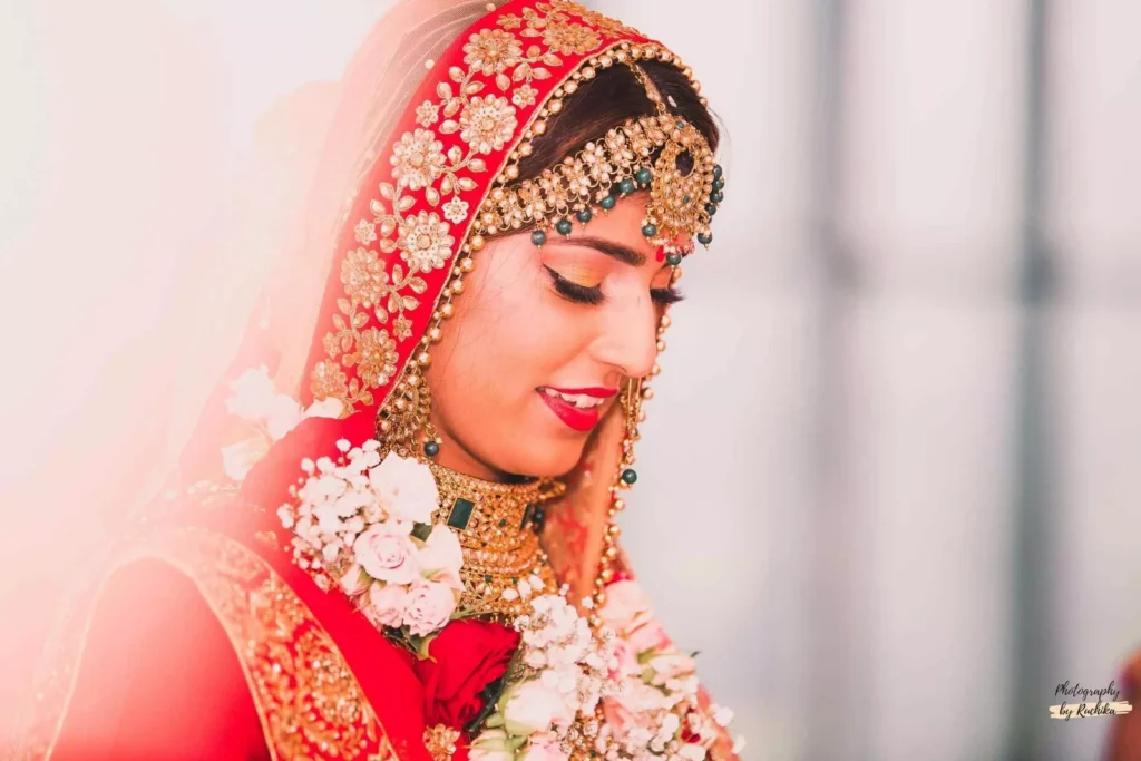 A stunning Indian bride in traditional red and gold wedding attire, captured during a ceremony in Wellington, New Zealand