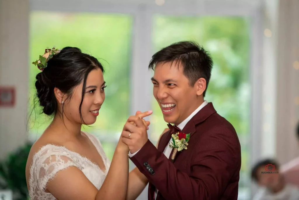 A newlywed couple sharing a joyful first dance moment at their wedding reception in Wellington, captured with natural expressions of love and happiness.