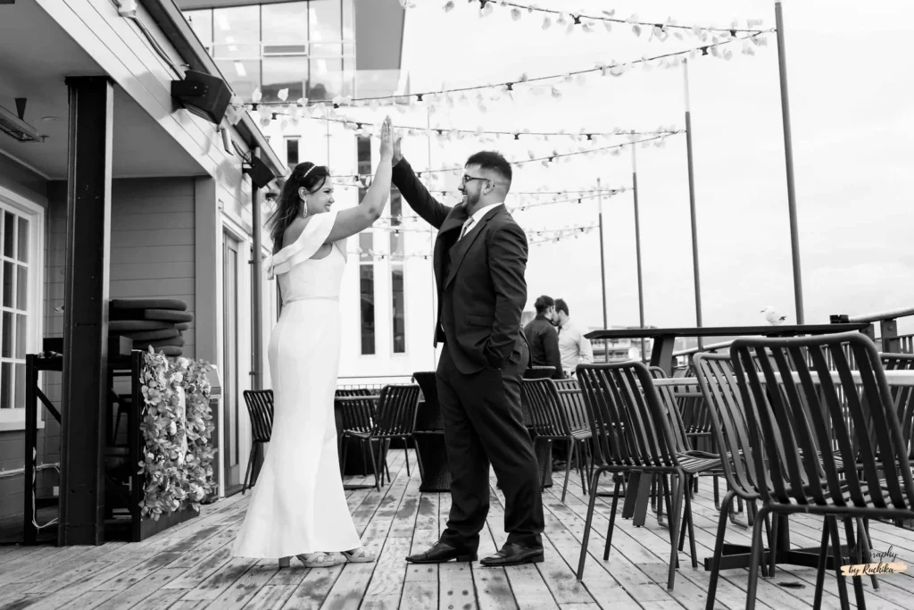 Bride and groom share a joyous moment during their wedding dance on a beautifully decorated deck in New Zealand