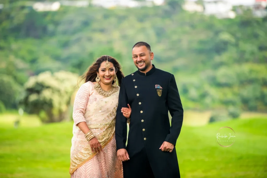 A beautifully dressed couple posing outdoors in a lush green setting during their wedding shoot in Wellington, New Zealand