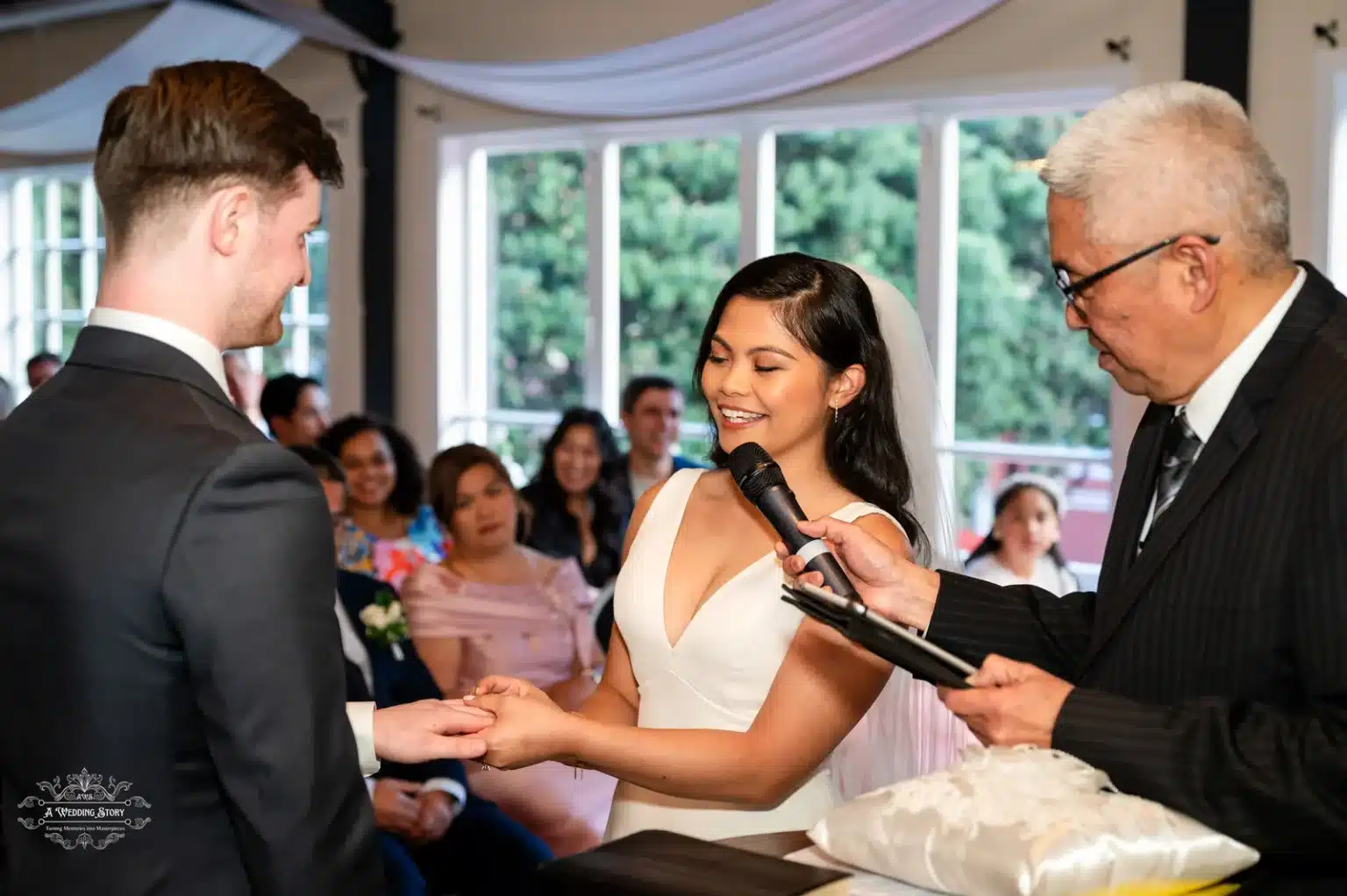 Bride exchanging rings with the groom, smiling brightly during the wedding ceremony, captured at an intimate venue in Wellington, New Zealand.