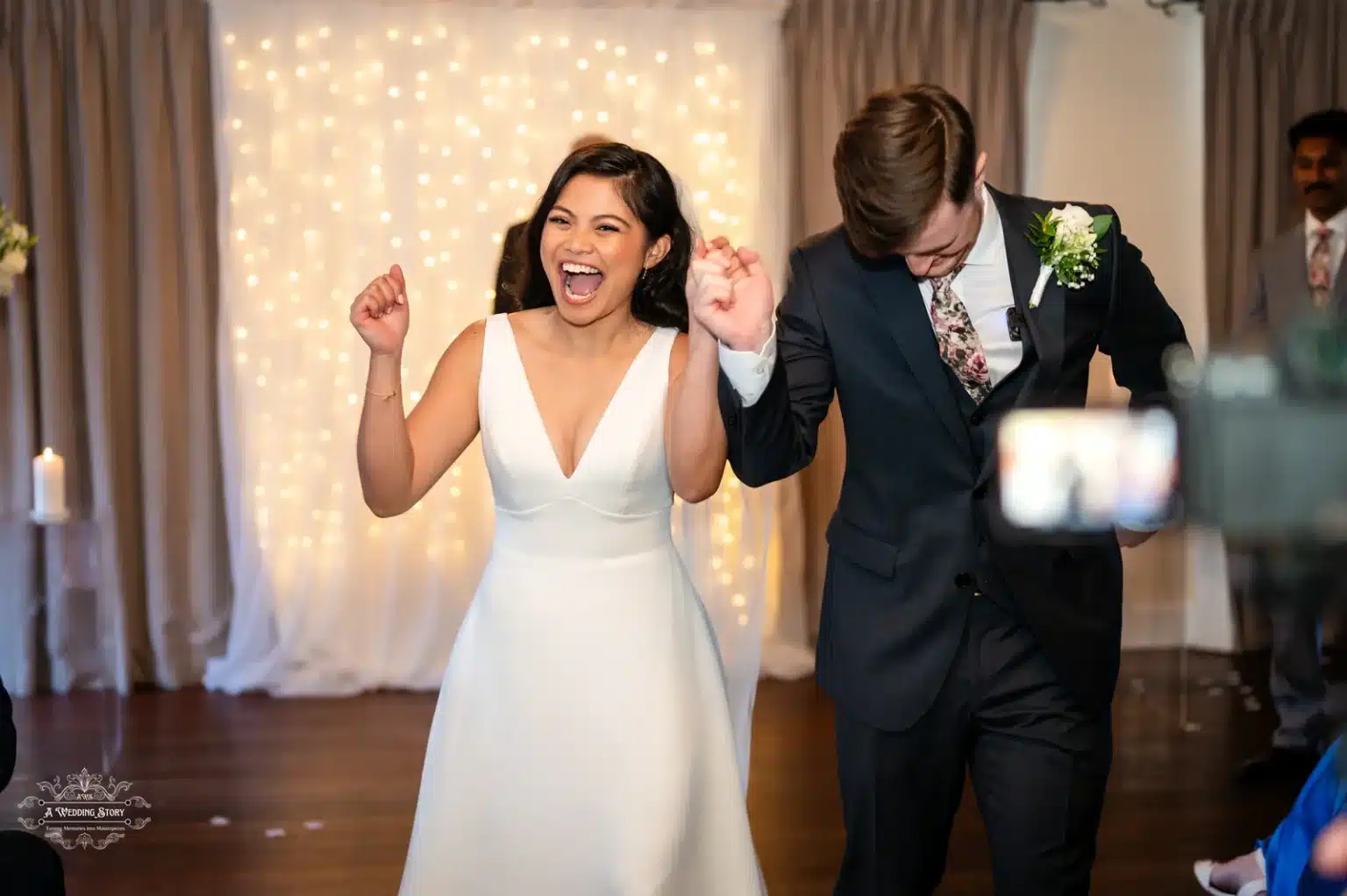 Newlywed couple celebrating with joy after their wedding ceremony in Wellington, captured with a radiant backdrop.