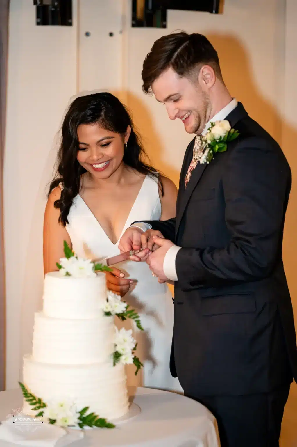 Bride and groom cutting their wedding cake at their wedding reception in Wellington, New Zealand.